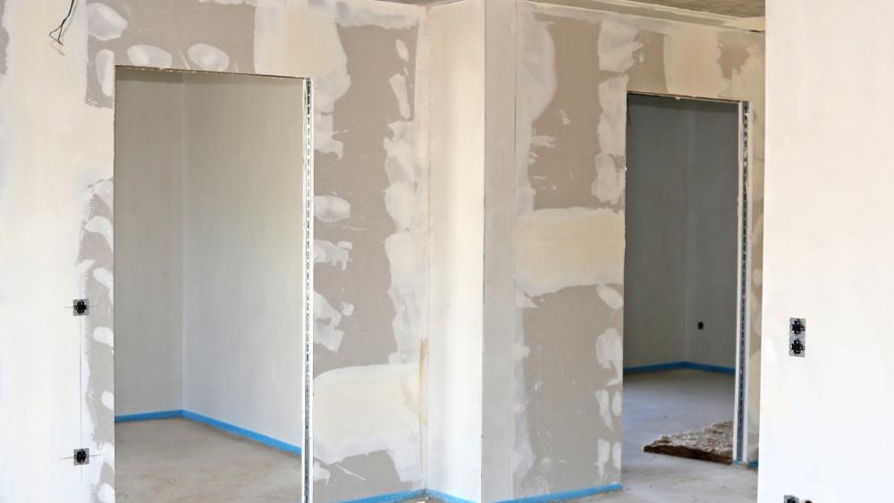 Das innere eines Neubaus mit neuem Estrich mit Randdämmstreifen und gespachteltem Gipkarton.