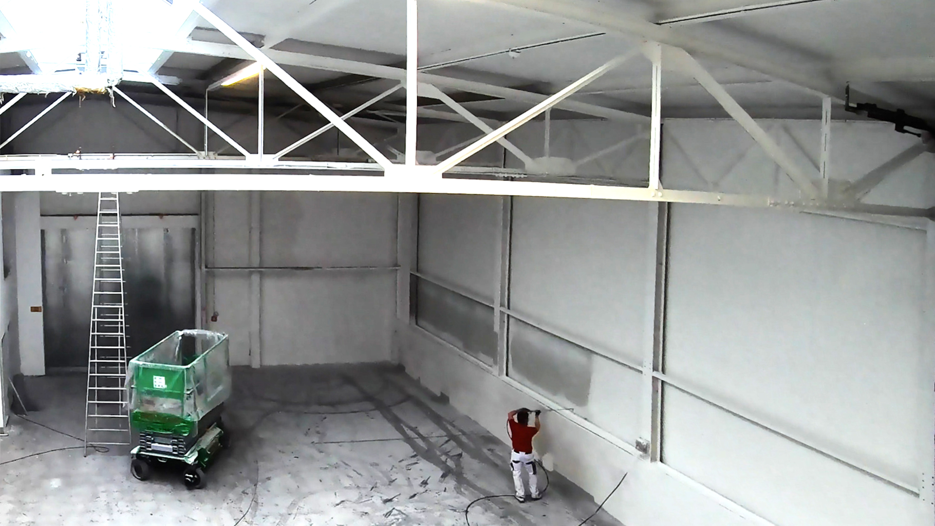 Verarbeitung von hawo Renofix an Wand im Airlesspritzverfahren in Lagerhalle