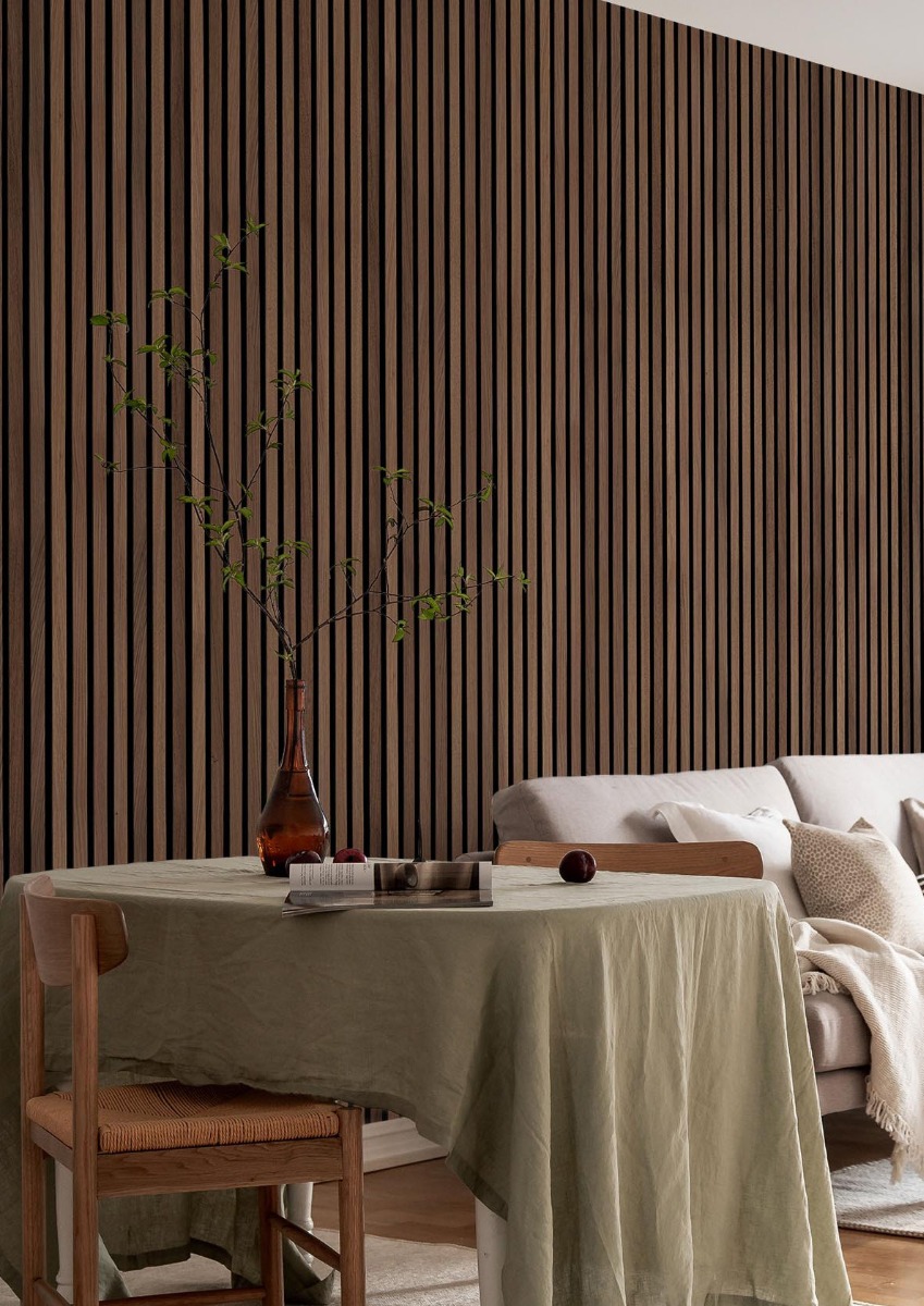 Tisch mit zwei Stühlen weiße Couch, dahinter dunkle Akustikpaneele