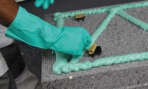 Eindrücken der hawo Dämmstoffkralle Quick in EPS-Dämmplatte und Abziehen der Schutzfolie von Dämmstoffkralle