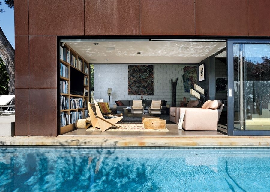 Fassaden mit Rostoptik, offene Balkon-Schiebet&uuml;r mit Blick ins Wohnzimmer, davor ein Pool
