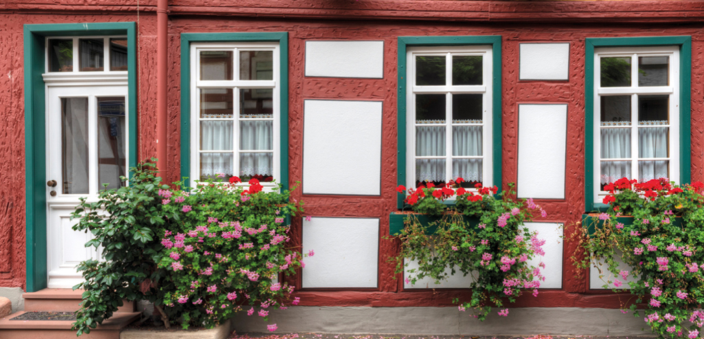 Fachwerkfassade mit roten und grünem Fachwerk und weißen Fesntern