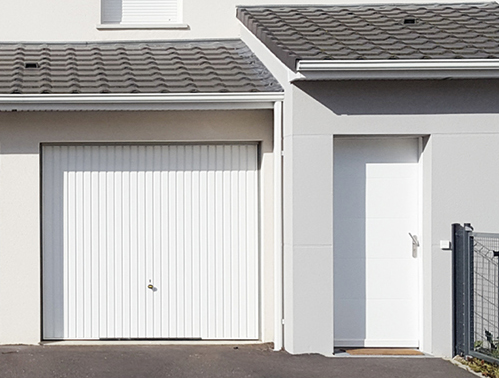 Garage mit weißer Fassade und weißem Garagentor und Tür