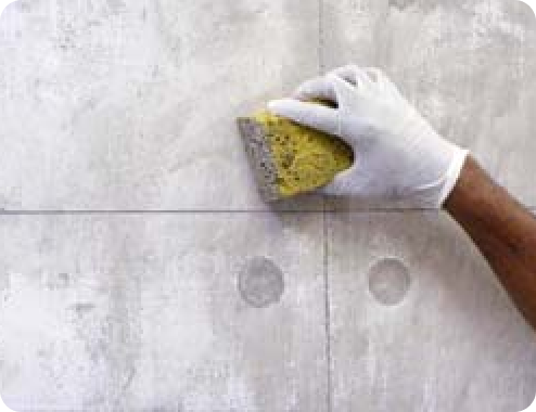 Hand mit Schwamm, die eine Betonoptik herstellt